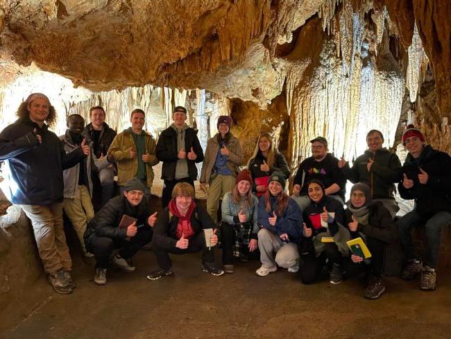 Group of students posing inside a cave